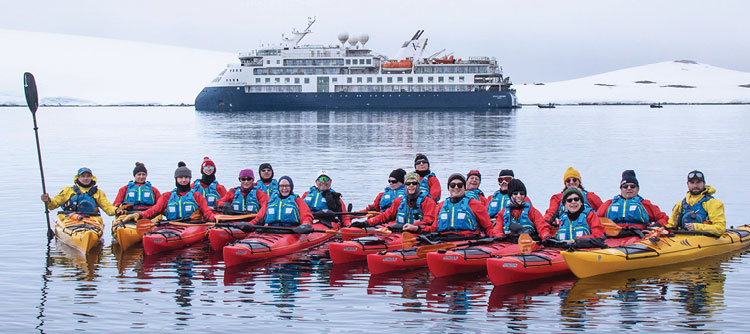 Expedition Team and passengers in Kayaks with Ocean Explorer in the background, Antarctica