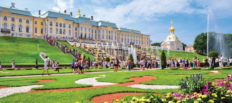Flowers, fountains and verdant lawns lead up to the Peterhof palace in St. Petersburg, Russia.