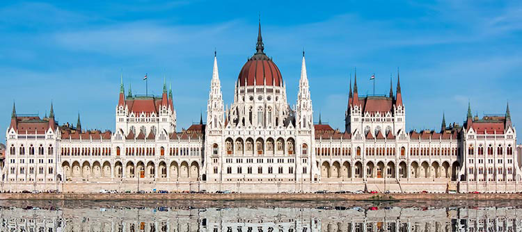 The grand, sprawling Parliament building reflected in the clear Danube waters.