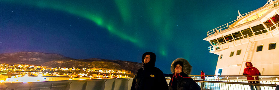 Travelers gazing at Northern lights on expedition cruise